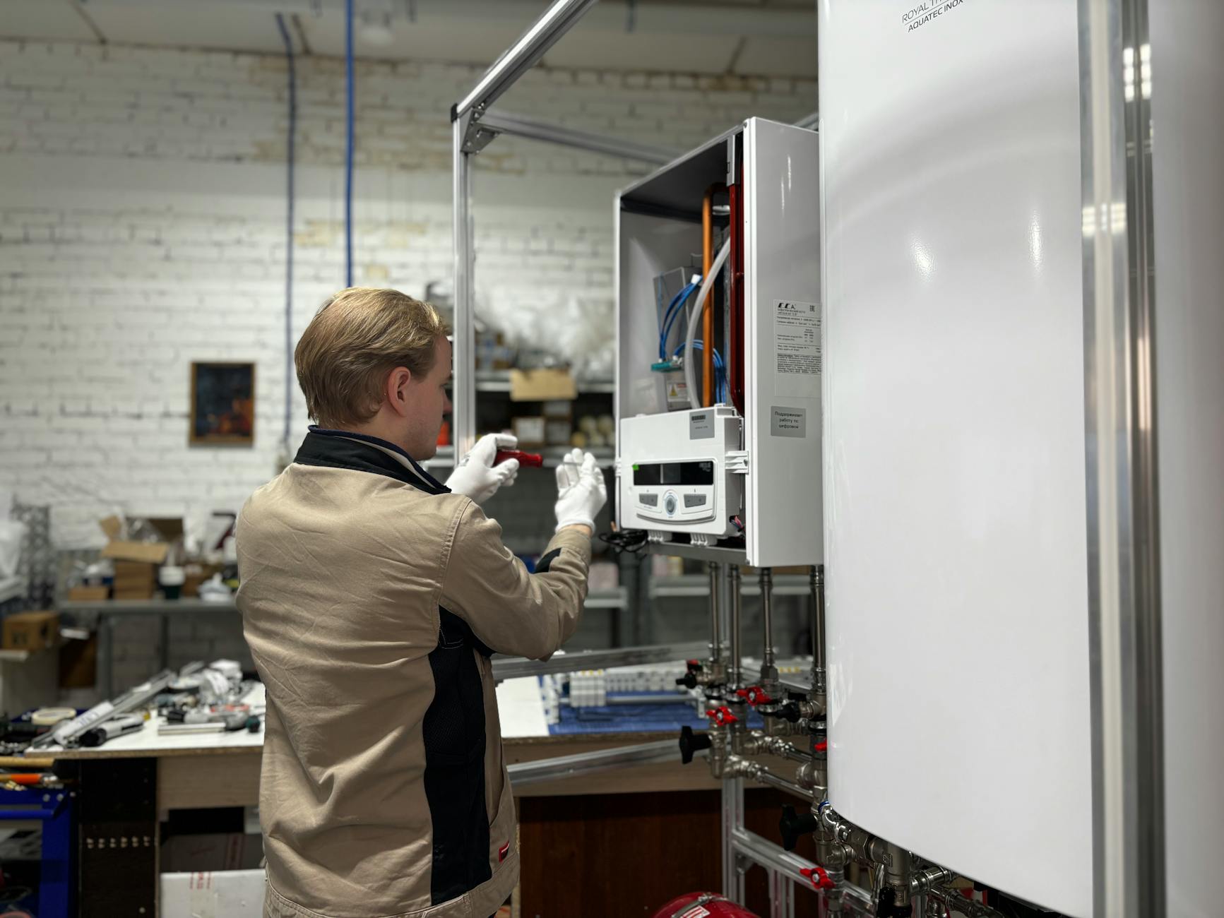 Gas engineer in uniform carrying out an annual boiler safety inspection