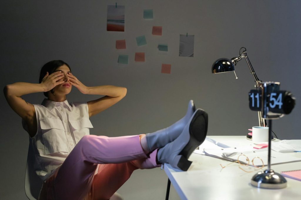 Woman stressed at kitchen table late at night checking compliance paperwork